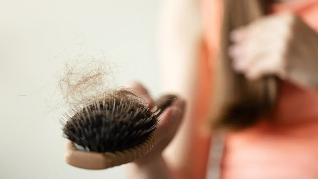 mulher analisando queda de cabelo na escova e dúvida se creatina causa queda capilar