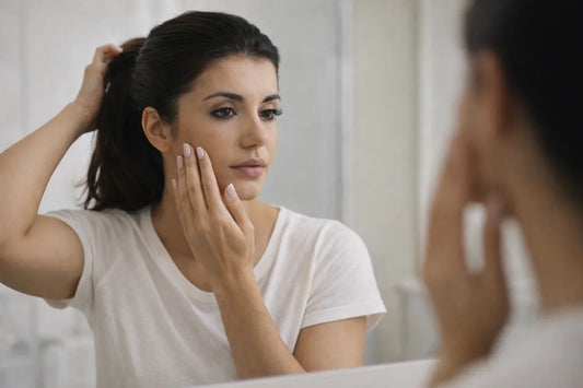 mulher observando pele e cabelo no espelho percebendo sinais de queda de colágeno